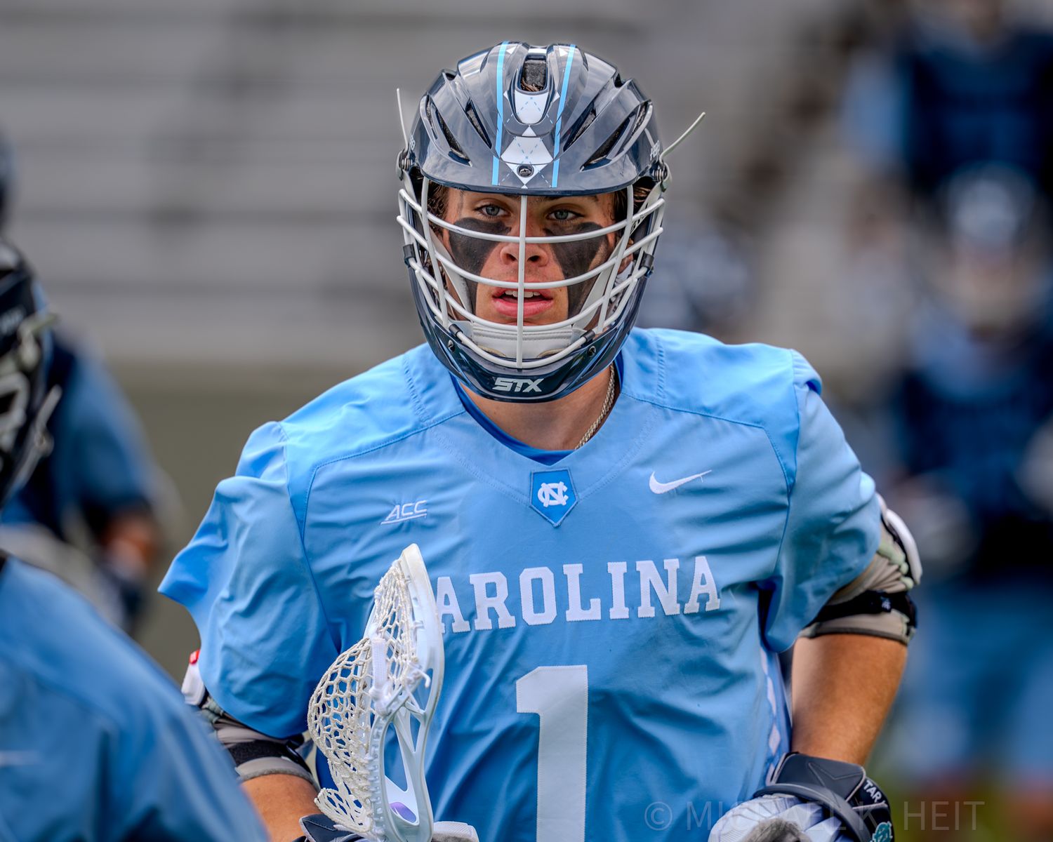 North Carolina lacrosse players in light blue uniforms during game action.