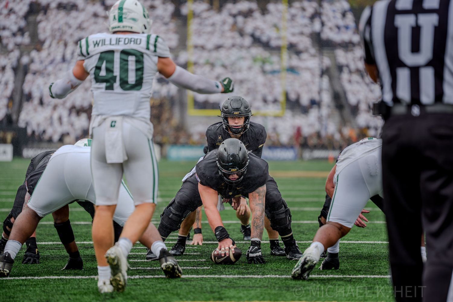Football players line up at the line of scrimmage during an intense play.