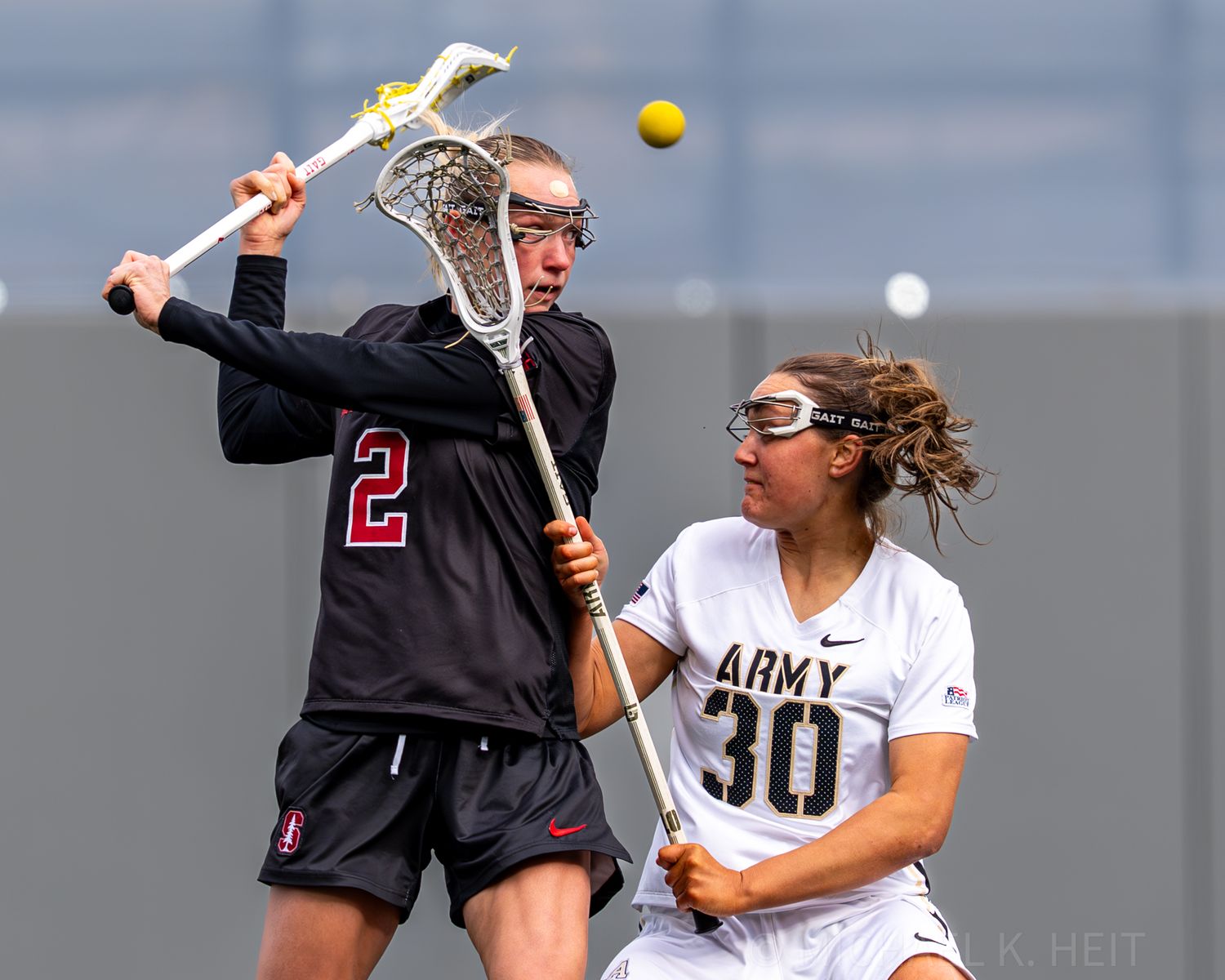 Players from Stanford and Army battle for control during an intense lacrosse match.