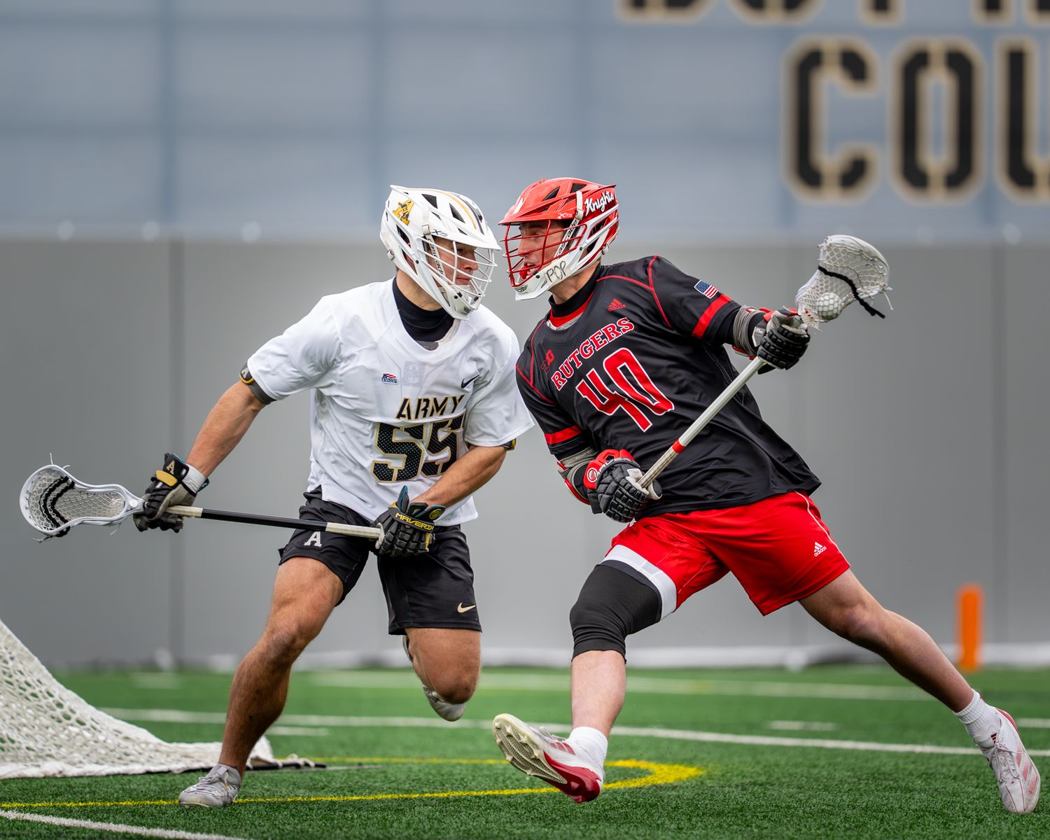 Players dive and stretch for the ball during intense lacrosse match action.