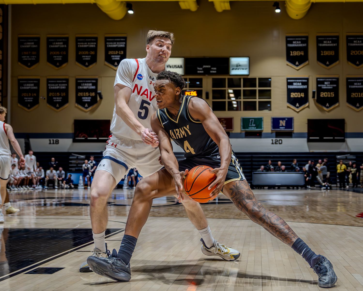 Close-up action shot of basketball players battling for control near the baseline during a game.
