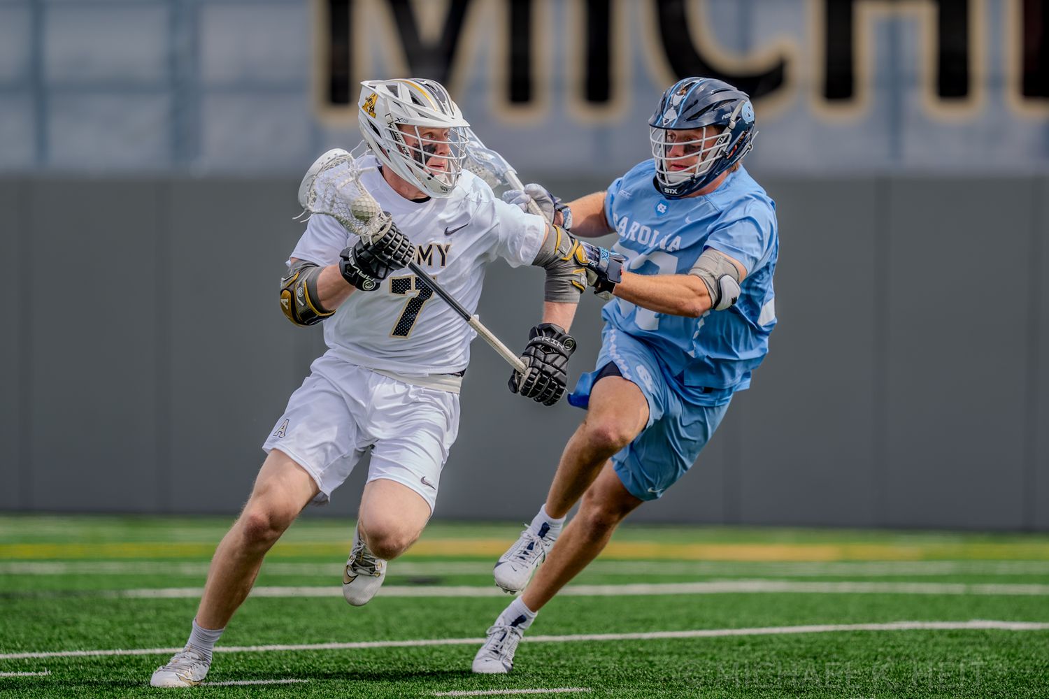 Players from Army and North Carolina battling during competitive lacrosse match.
