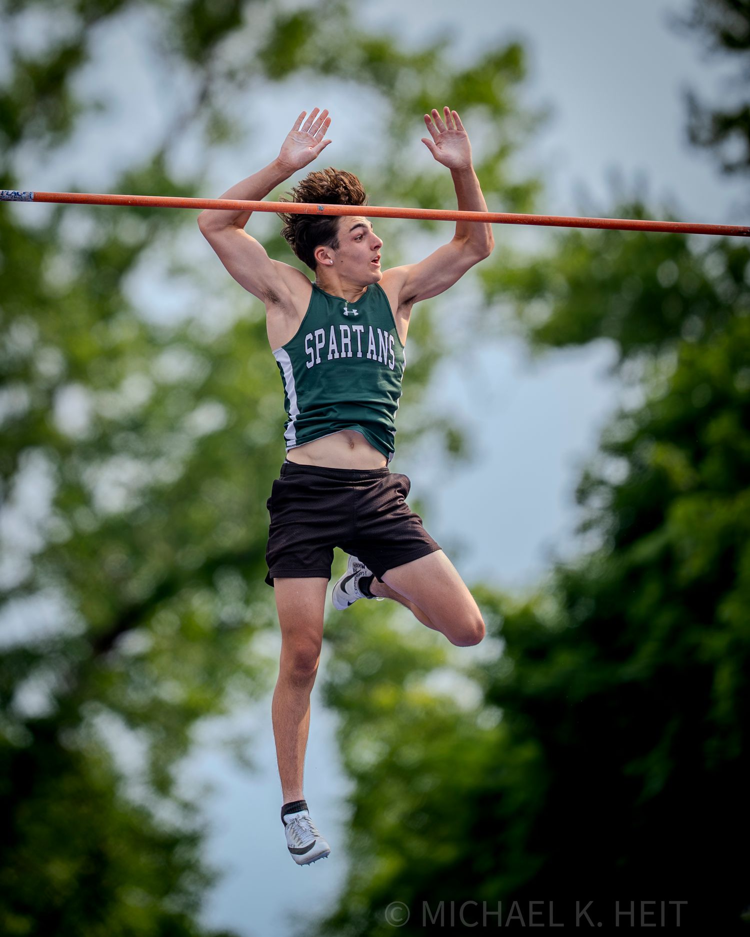 Sequence showing high jump technique during outdoor competition.