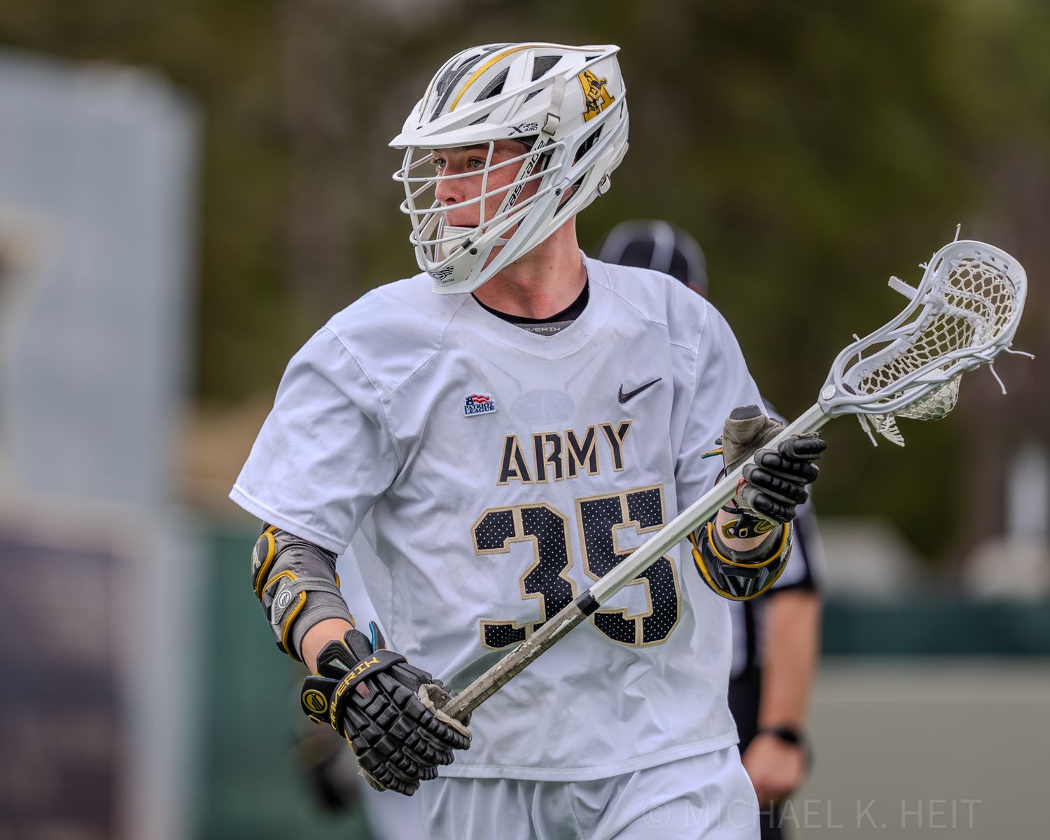 Lacrosse players from Army and Carolina compete during an intense match on the field.