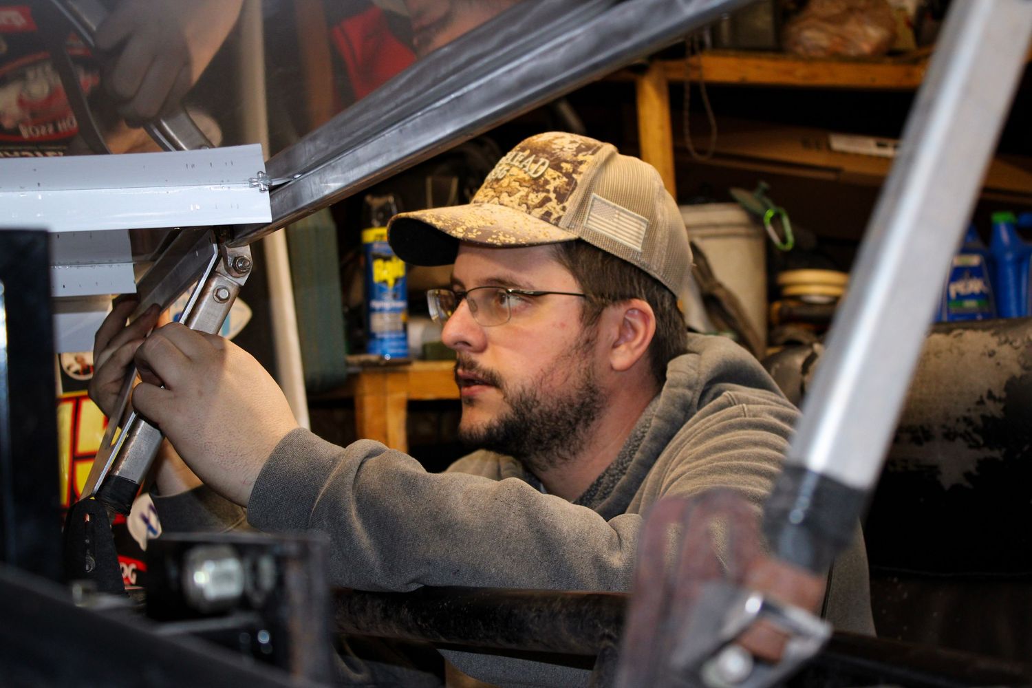 Close up shot of someone working on automotive repairs in a garage setting.