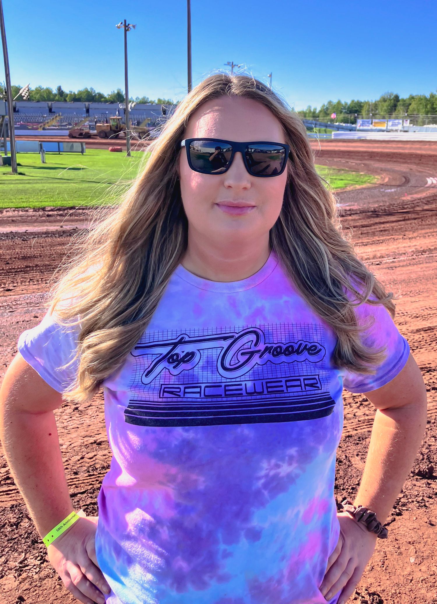 Purple tie-dye t-shirt with custom graphics displayed on dirt race track.