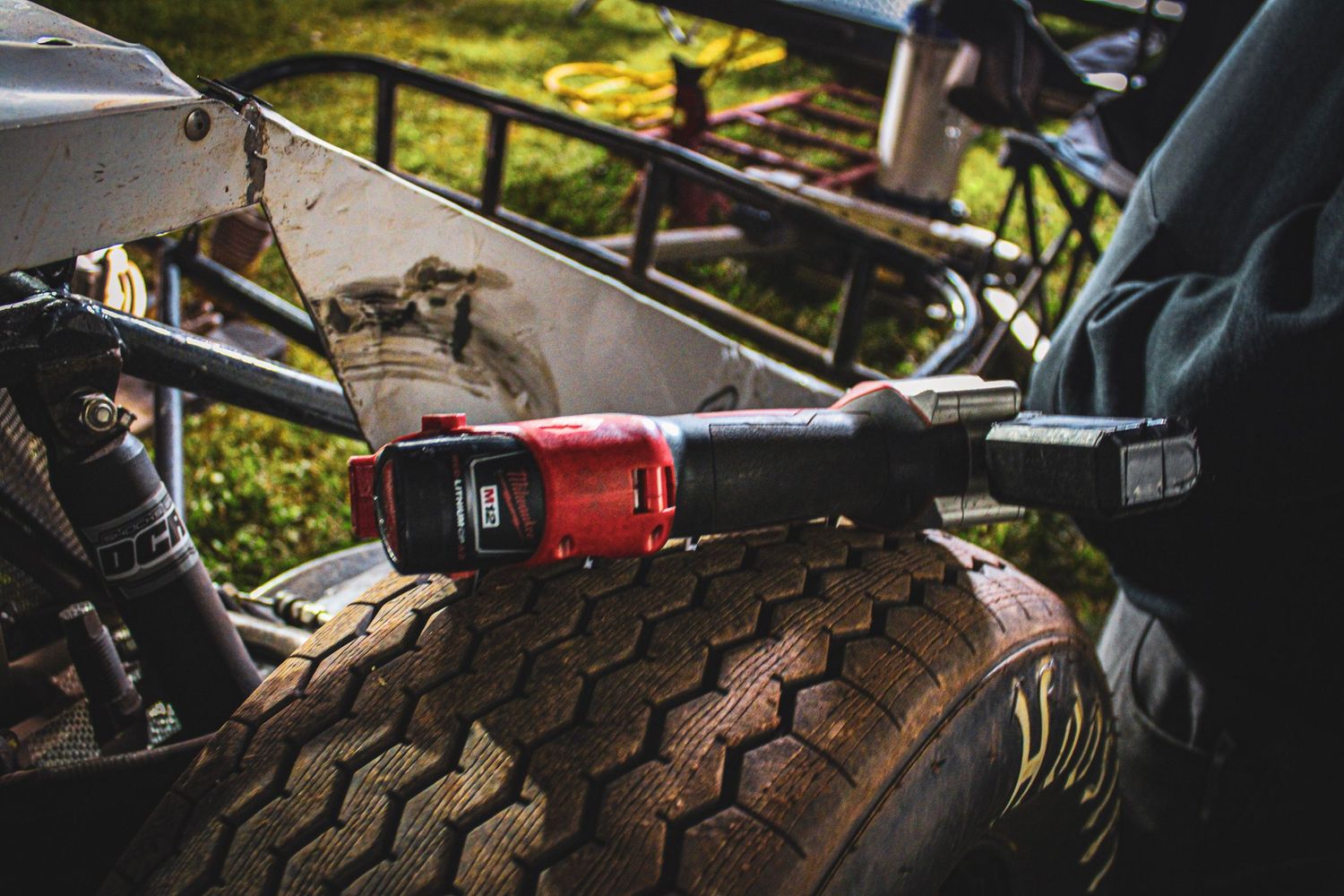 Close-up shot of a power tool being used on a tire with rugged tread pattern.