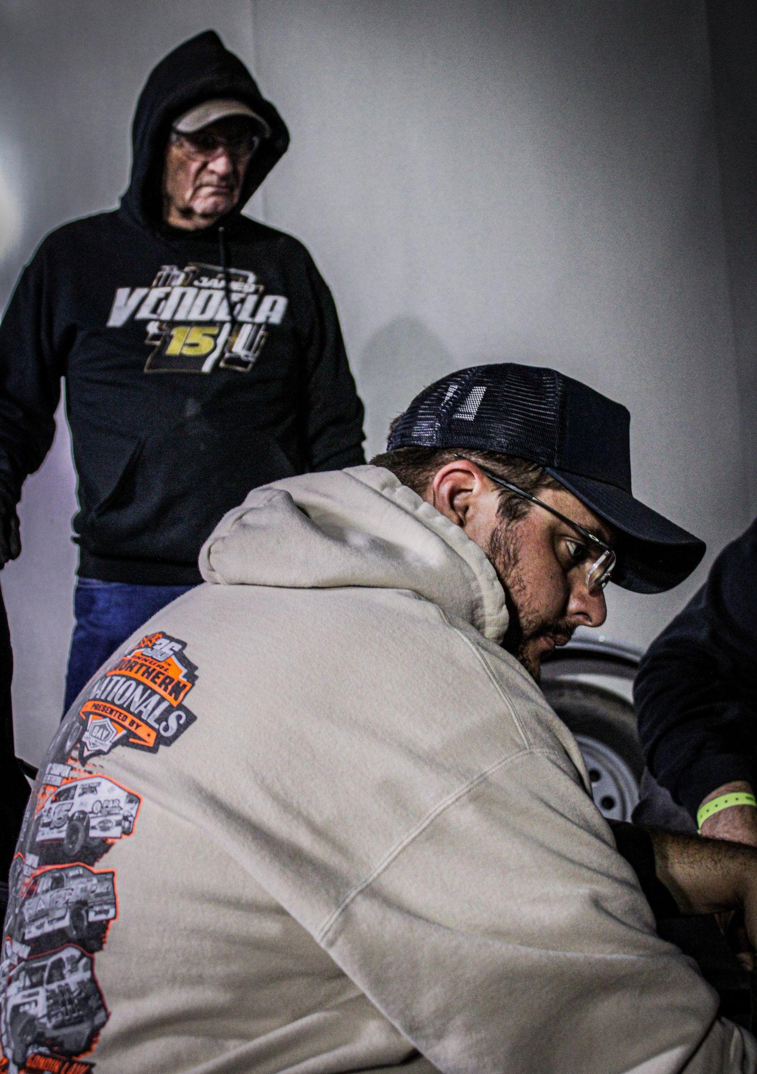 Workshop scene with people in baseball caps and branded apparel working together.