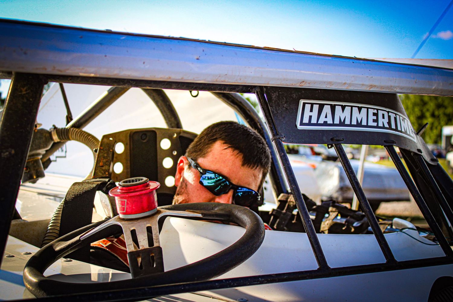 Race car windshield views showing Hammertime branding against blue sky.