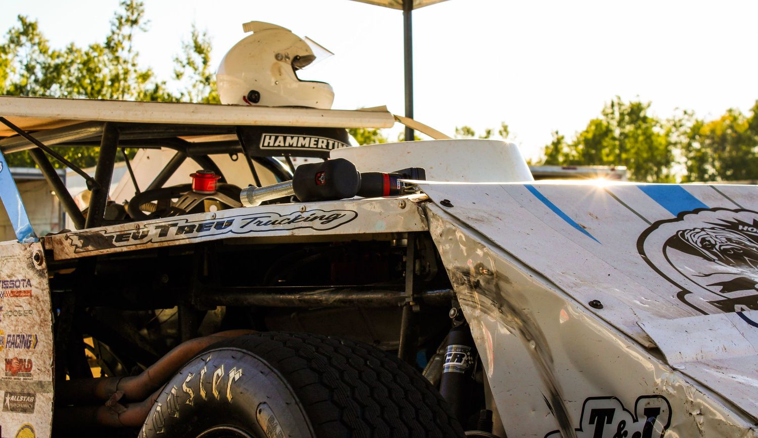 Racing car parts and mechanical equipment laid out in a garage or pit area.