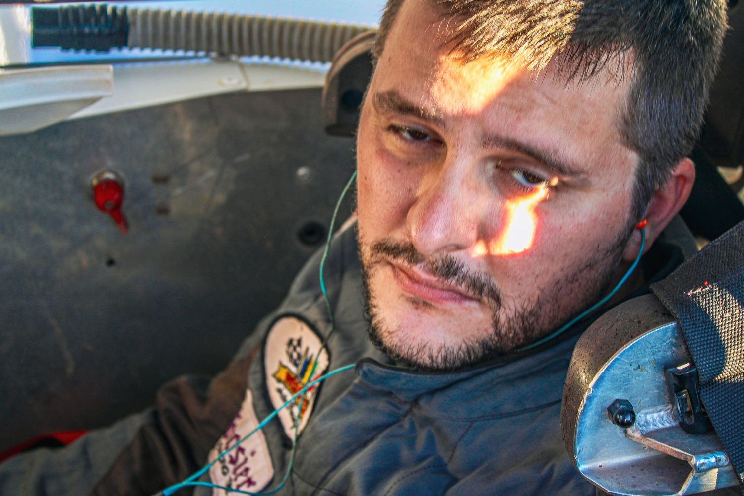 A series of close-up shots showing a person in racing gear during a motorsport event.