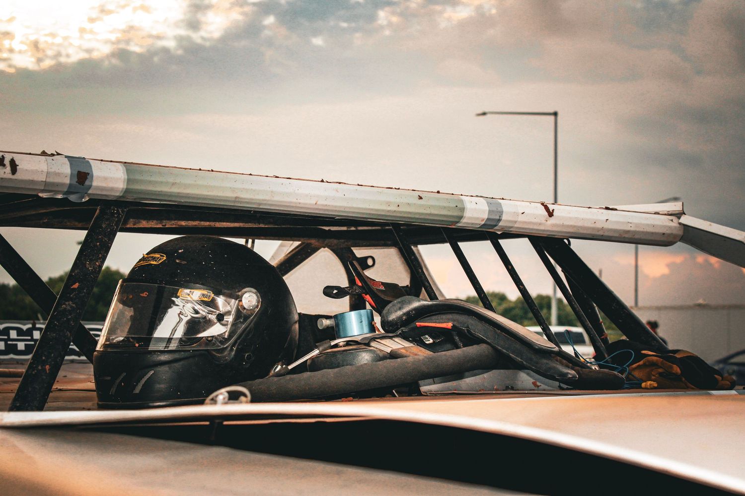 Interior view of a race car cockpit with roll cage and safety equipment visible.