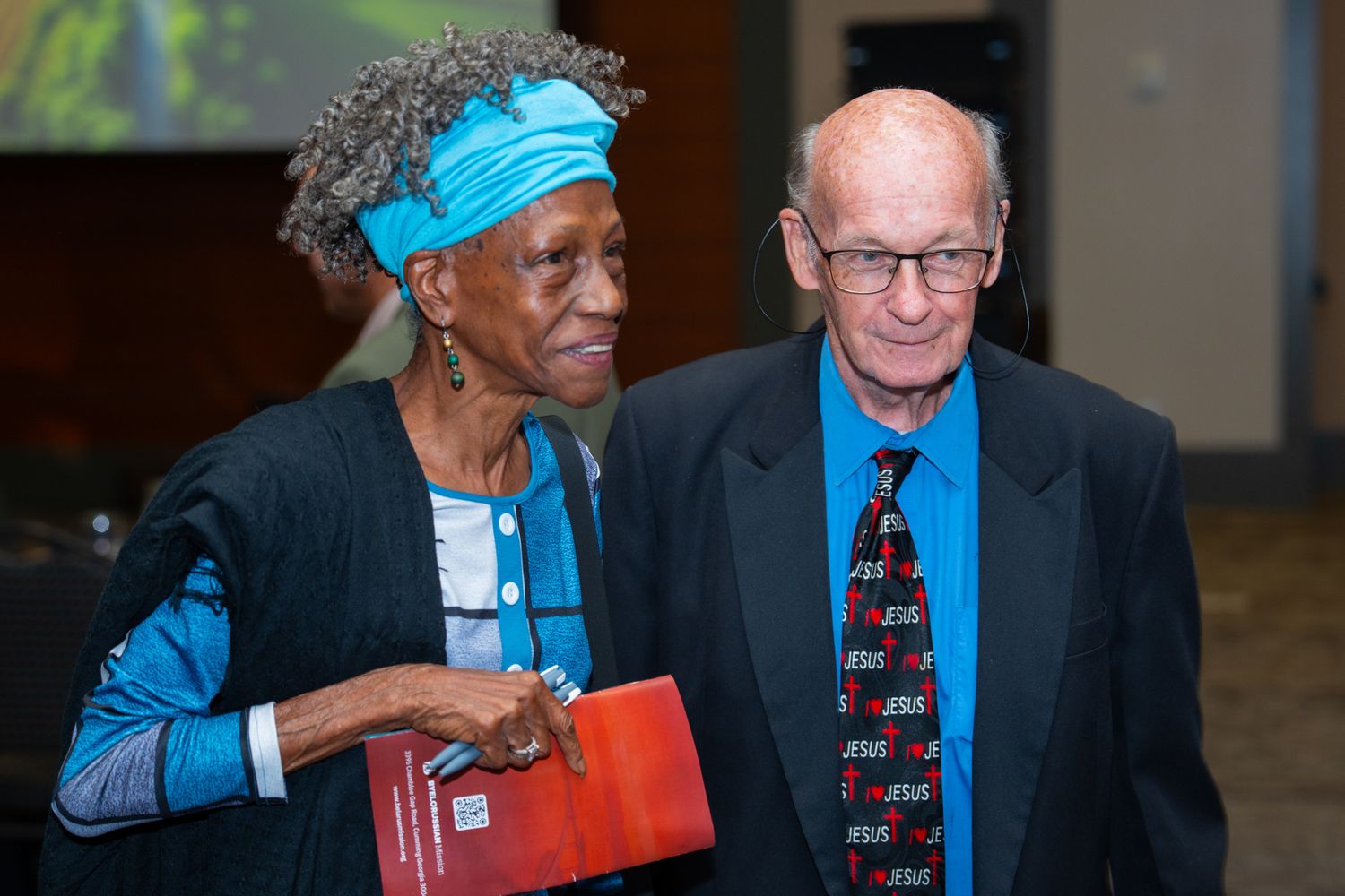 Attendees at event looking at books with blue accents in their attire.