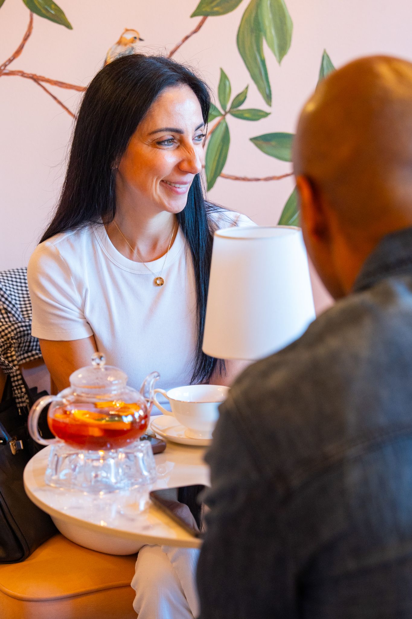 People seated at a restaurant table engaged in conversation with drinks.