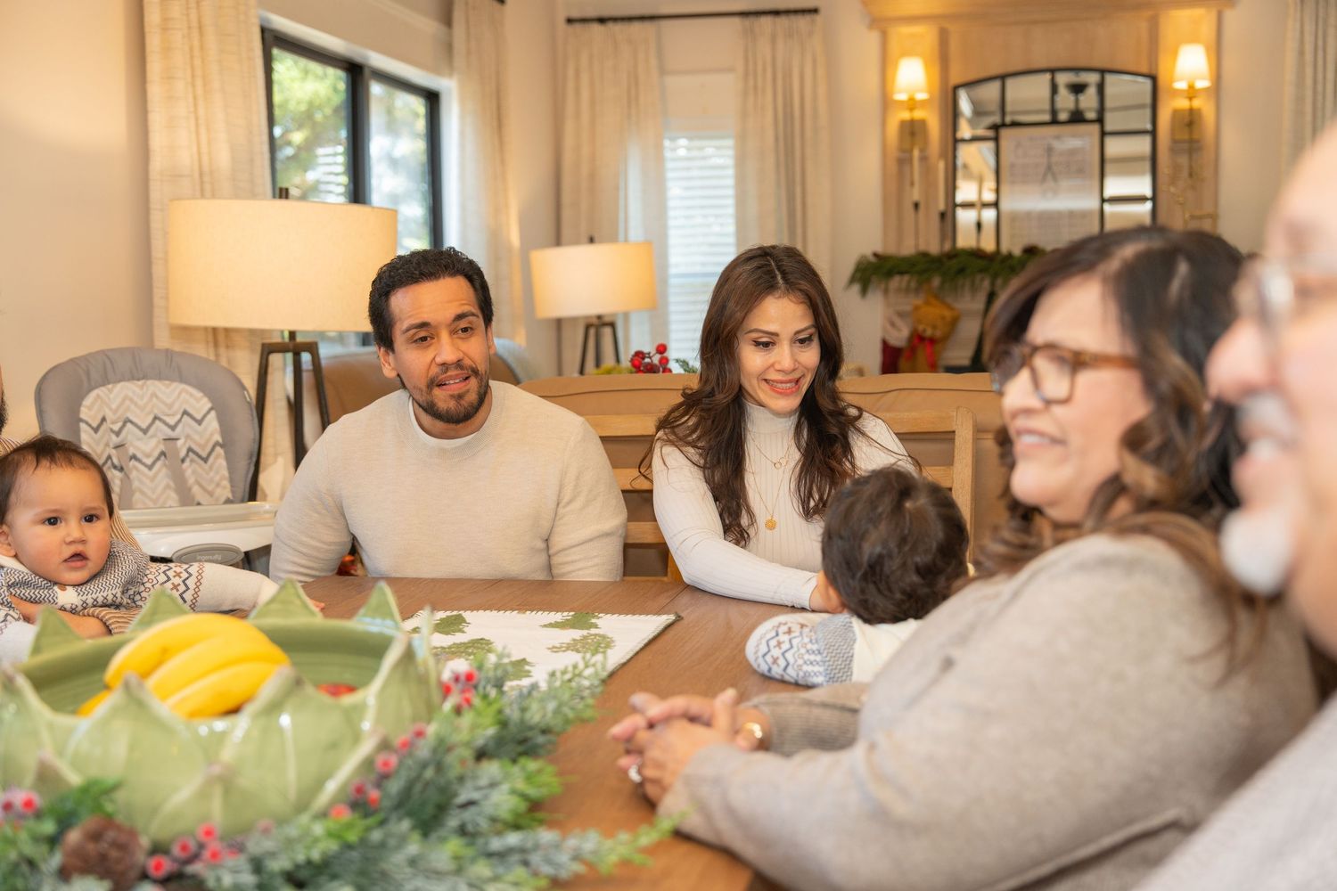 Candid family moments captured in a living room decorated for the holidays with warm lighting.