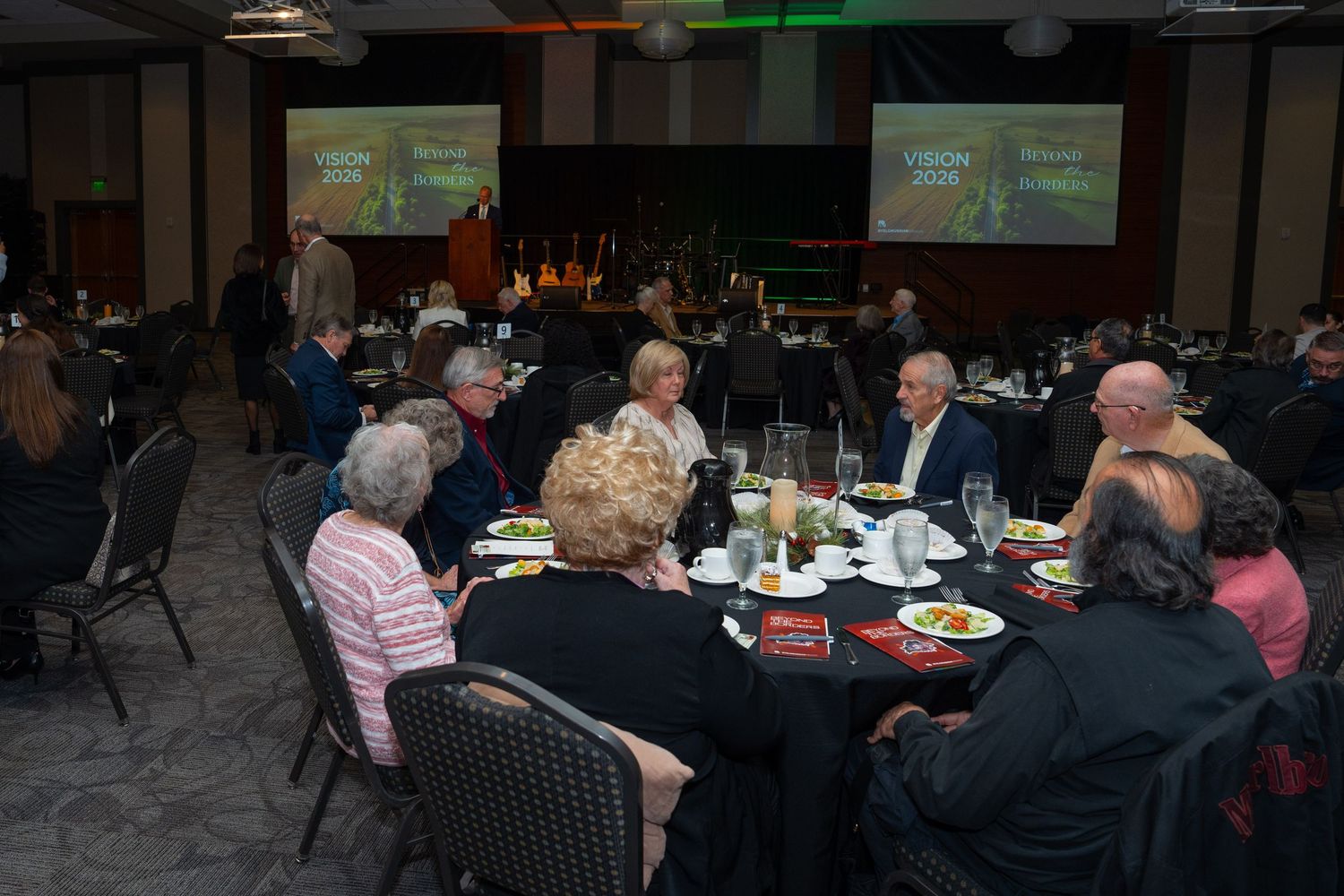 People gathered at tables in a dimly lit restaurant setting for a social dining event.