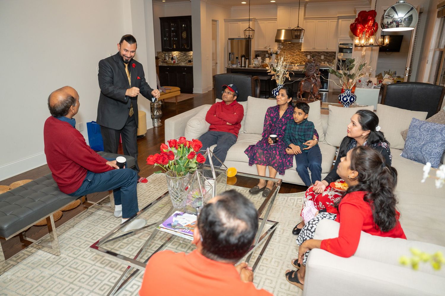A group of people gathered in a living room setting for a social event or gathering.