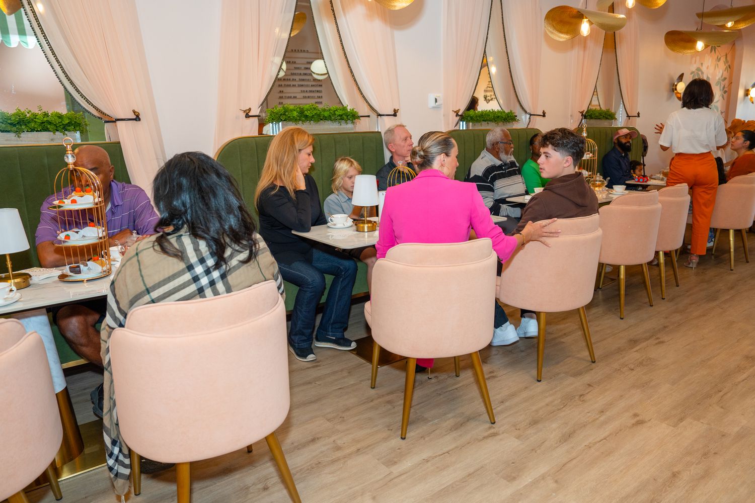 Interior view of modern restaurant with pink chairs and decorative lighting.