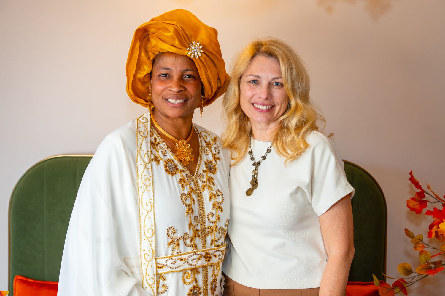 People posing together in traditional gold-embellished attire at an event.