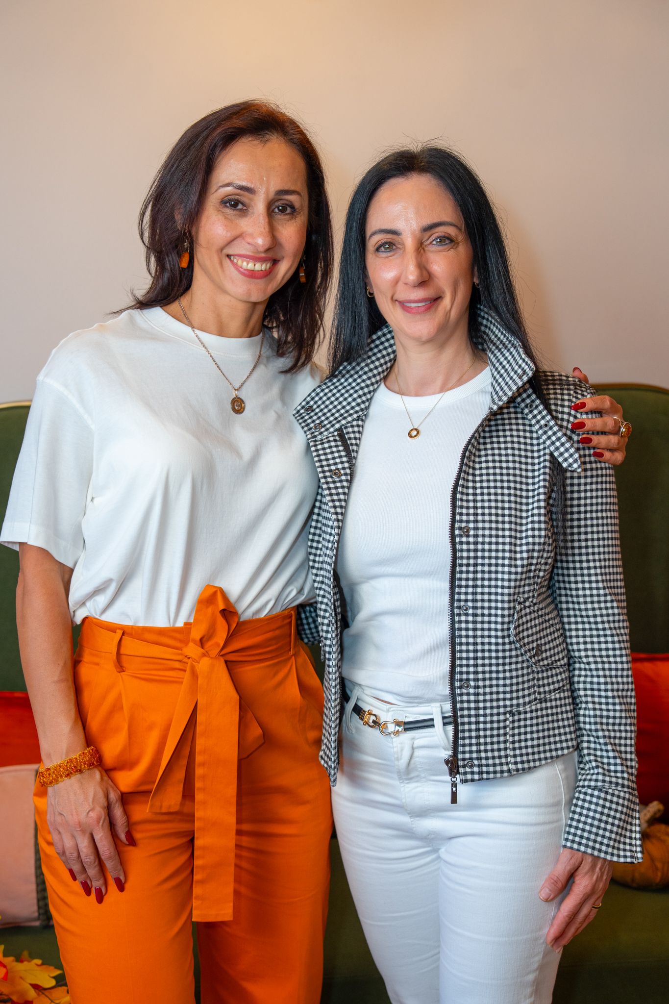 People wearing coordinated white and orange outfits posing together at an event.