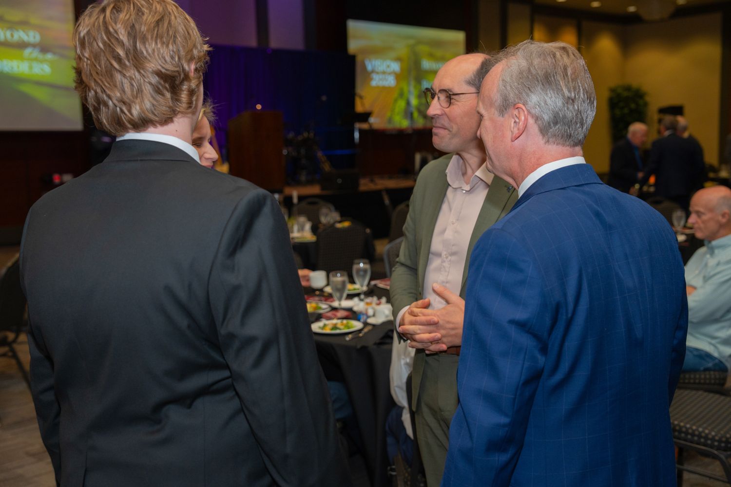 Business professionals mingling and networking at an evening conference event.