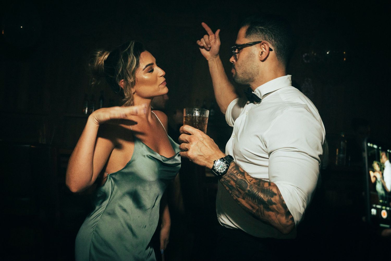 Couples dancing together in a dimly lit venue during an evening celebration.