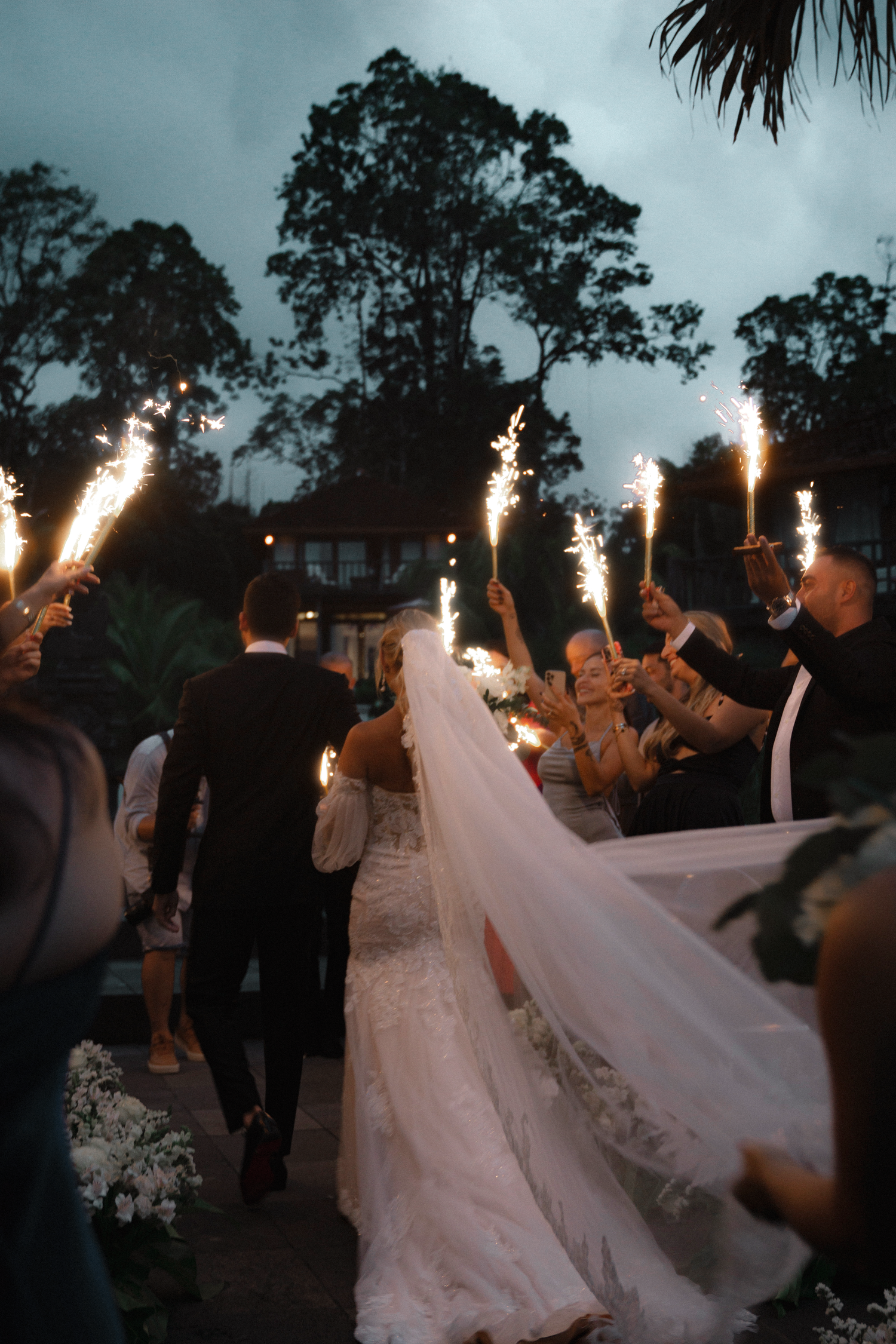 Wedding celebration at dusk with sparklers creating a magical atmosphere.