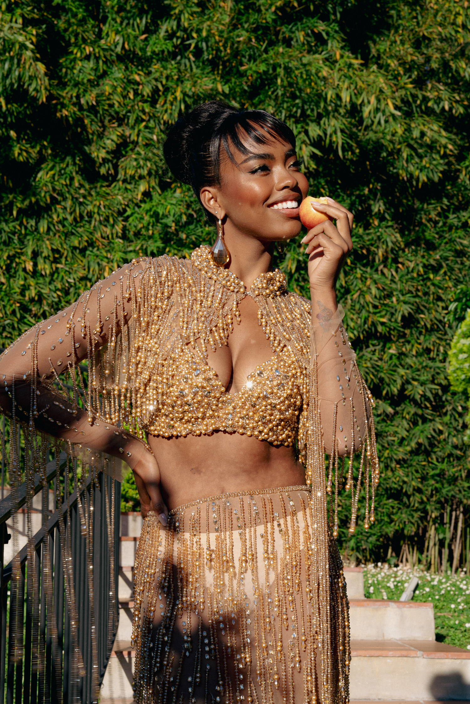 Glamorous gold sequined outfit sparkles in outdoor photoshoot.