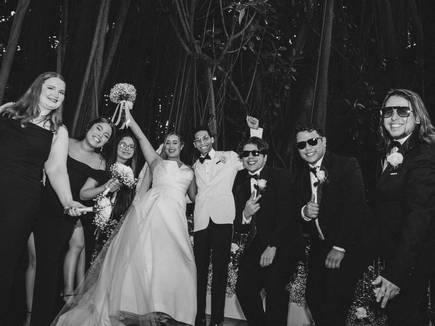 Wedding party celebrating in formal attire at evening reception.