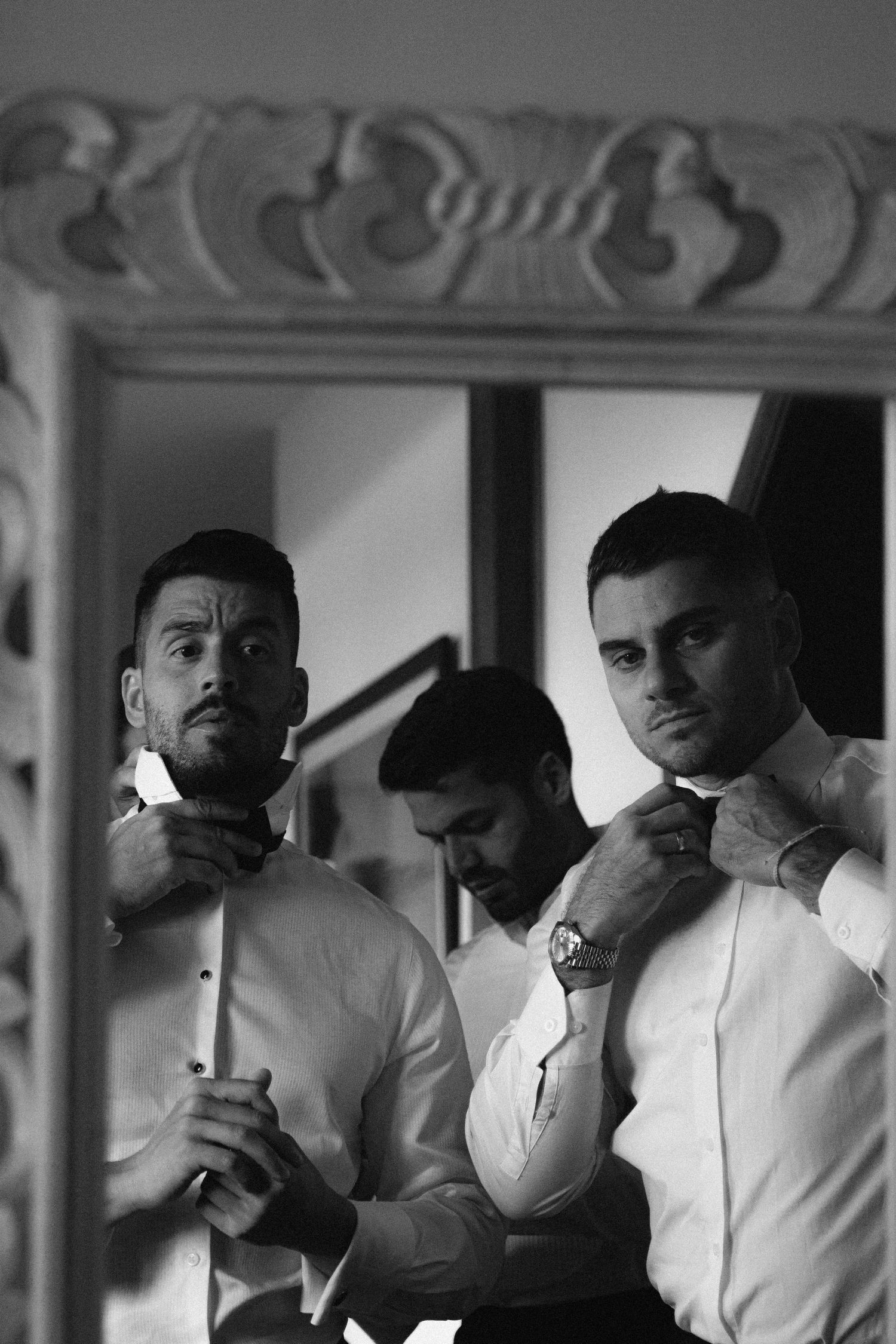 Group of men in white dress shirts gathered together in formal attire.