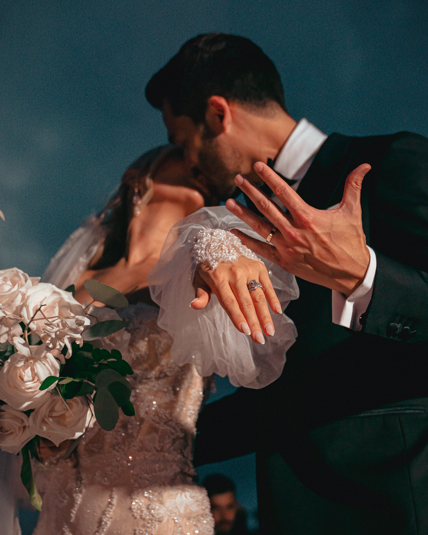 Close-up details of a wedding couple dancing, focusing on elegant dress details.