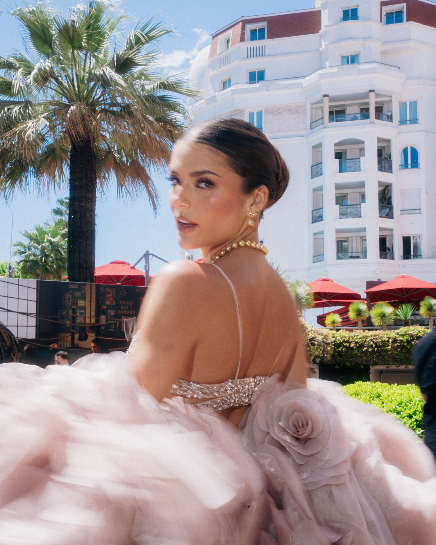 Elegant portrait session showcasing blush pink gown against Mediterranean-style architecture.