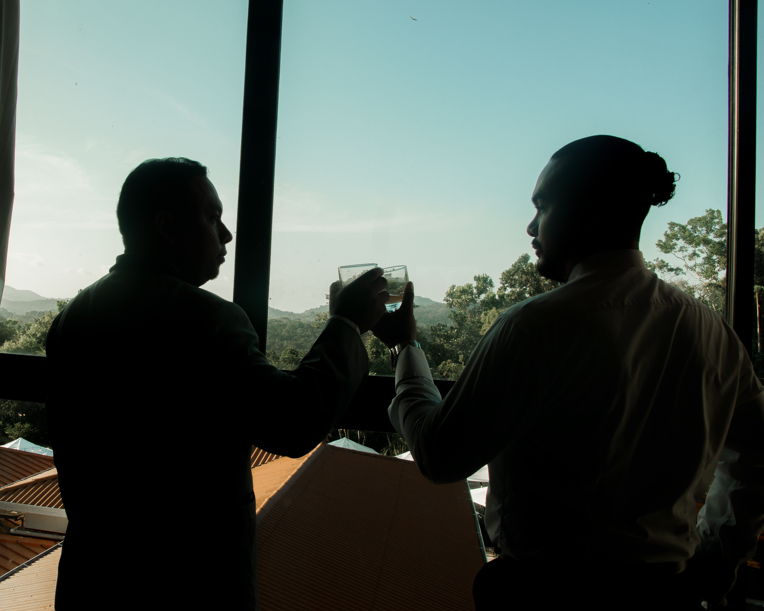 Silhouetted figures against large windows creating a dramatic panoramic composition.