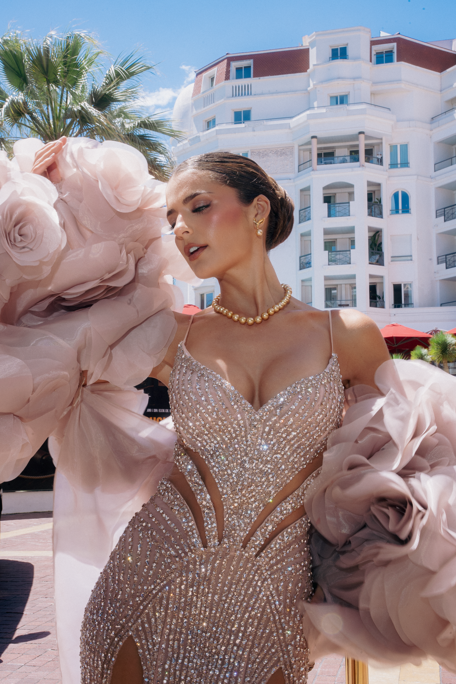 Stunning beaded gown with dramatic pink ruffles photographed at luxury resort location.