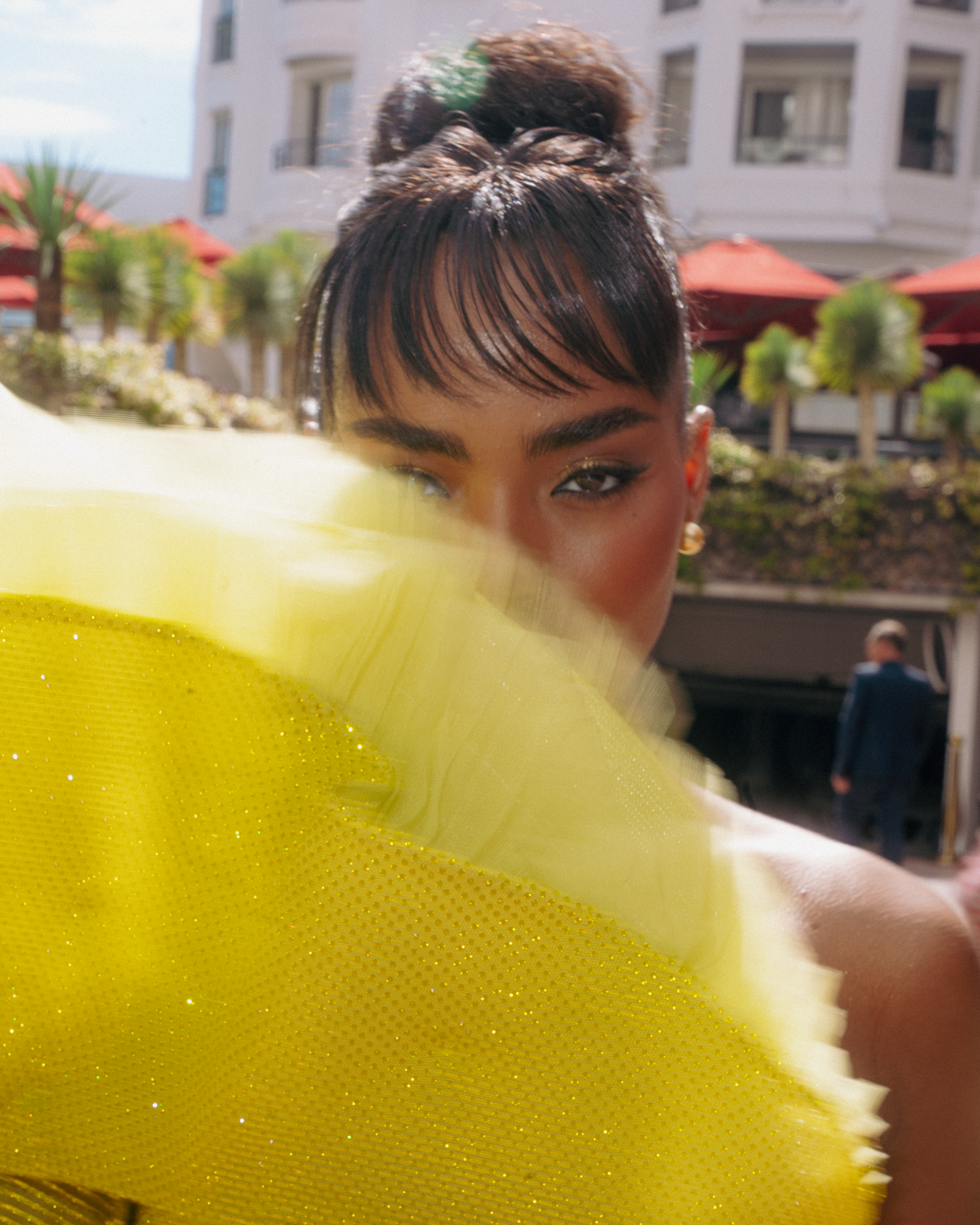 Fashion portrait with bright yellow fan creating dramatic lighting and shadows.