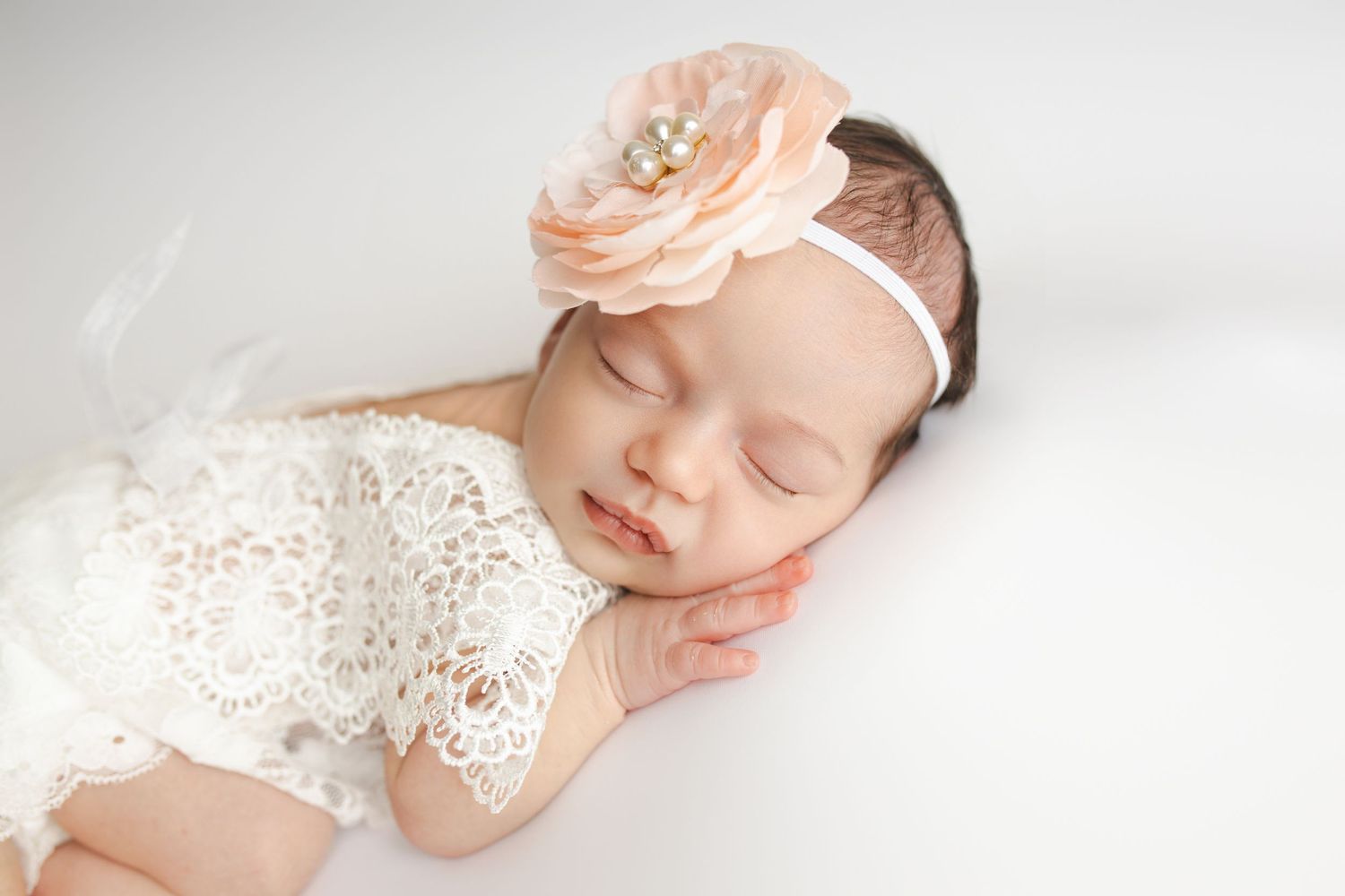 A collection of soft pastel newborn photography portraits featuring delicate lace details and floral accessories.