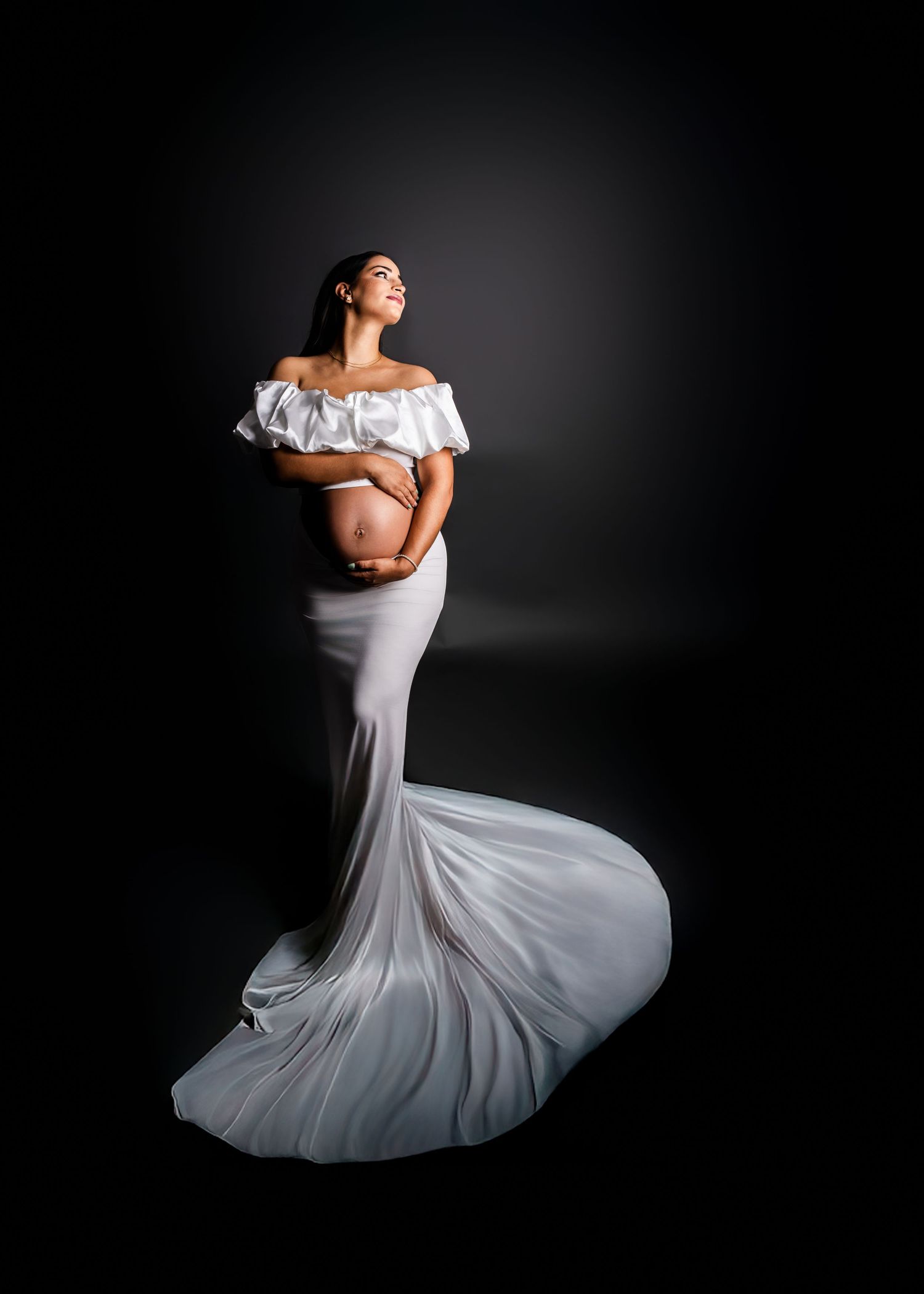 A graceful figure in a flowing white off-shoulder dress performs an elegant twirling dance motion against a dark background.