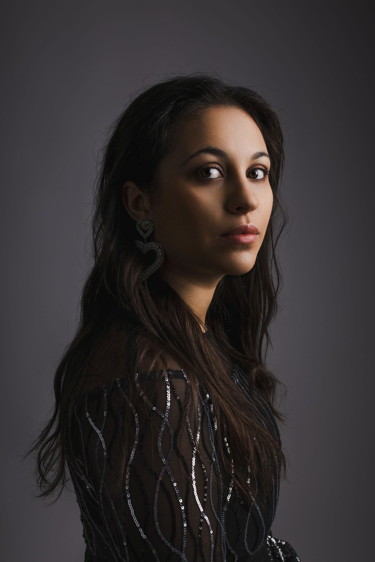 Dramatic portrait series against dark background showing woman with long dark hair in moody lighting.