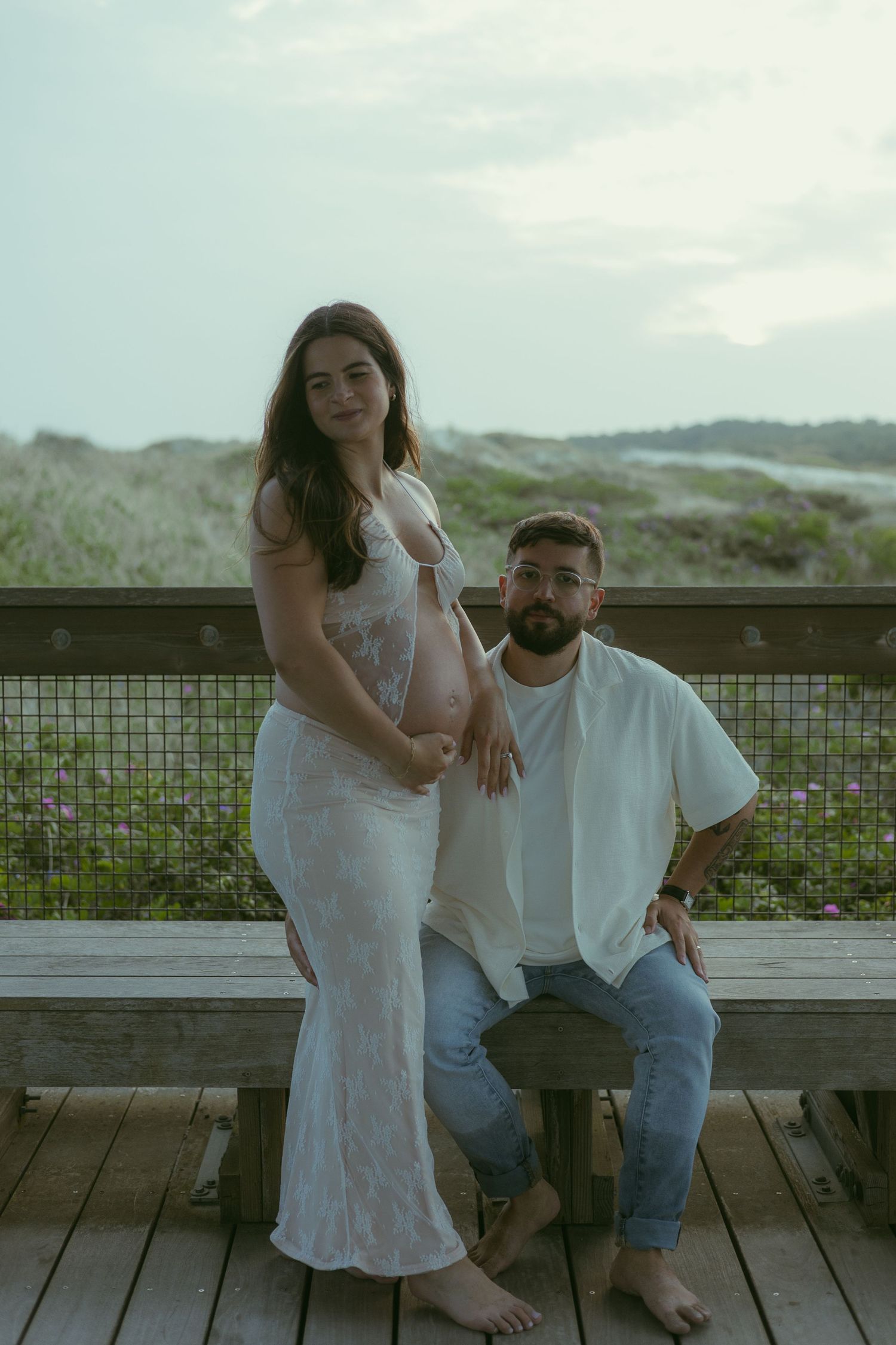 A casual outdoor photoshoot on a wooden deck by the coast.