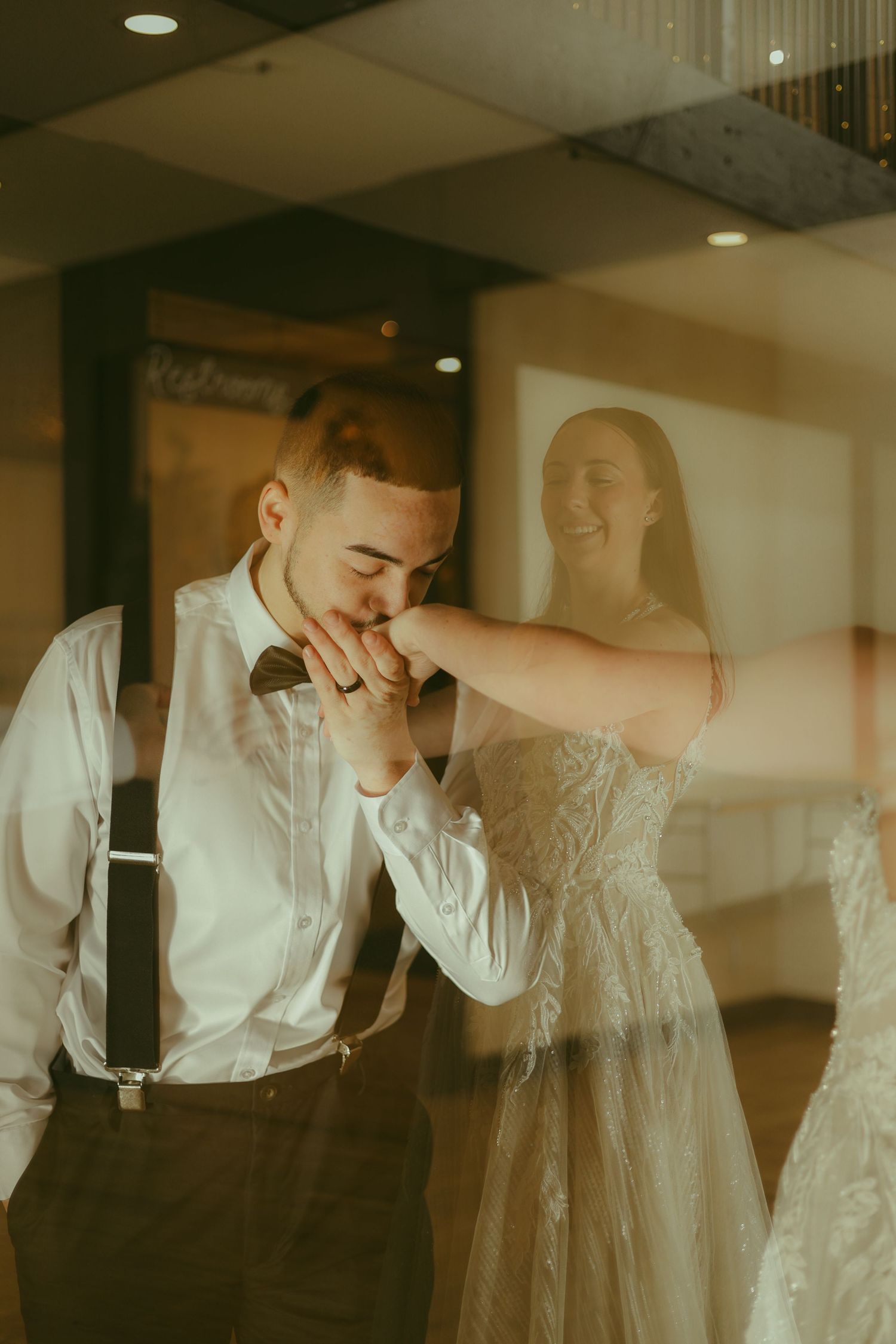 A tender moment captured between a couple in wedding attire with warm lighting.
