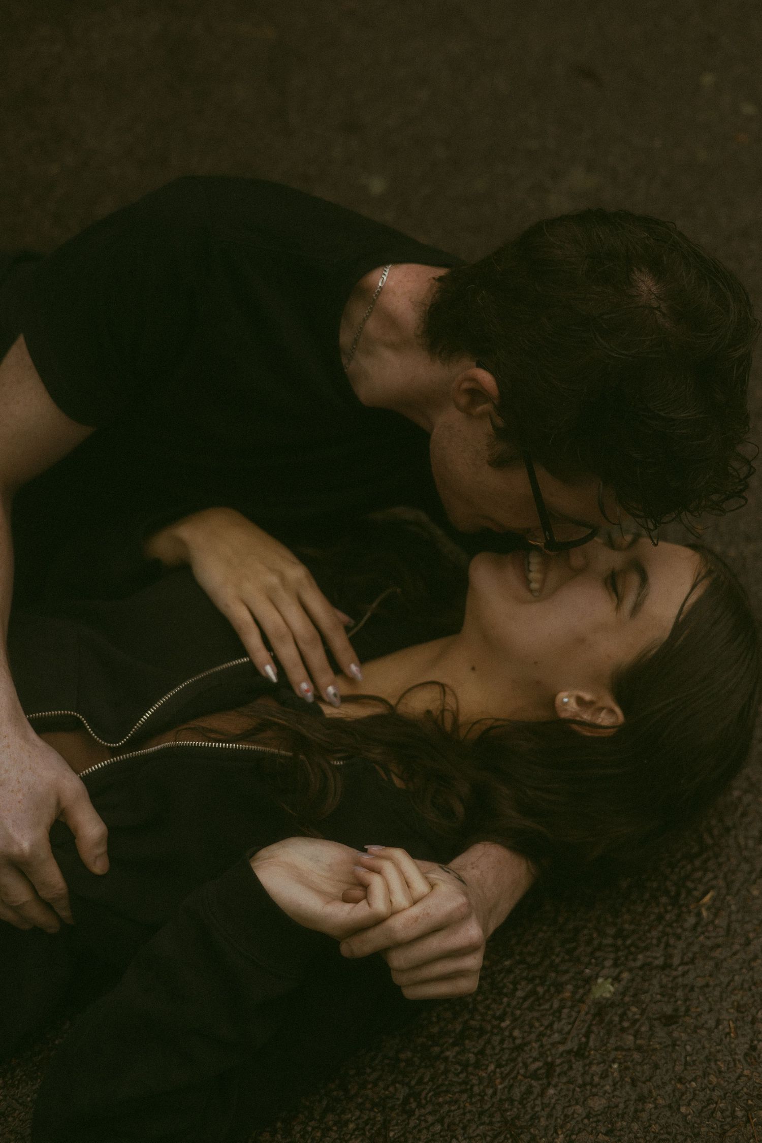 A series of intimate dark-toned photographs showing someone lying down on carpet.