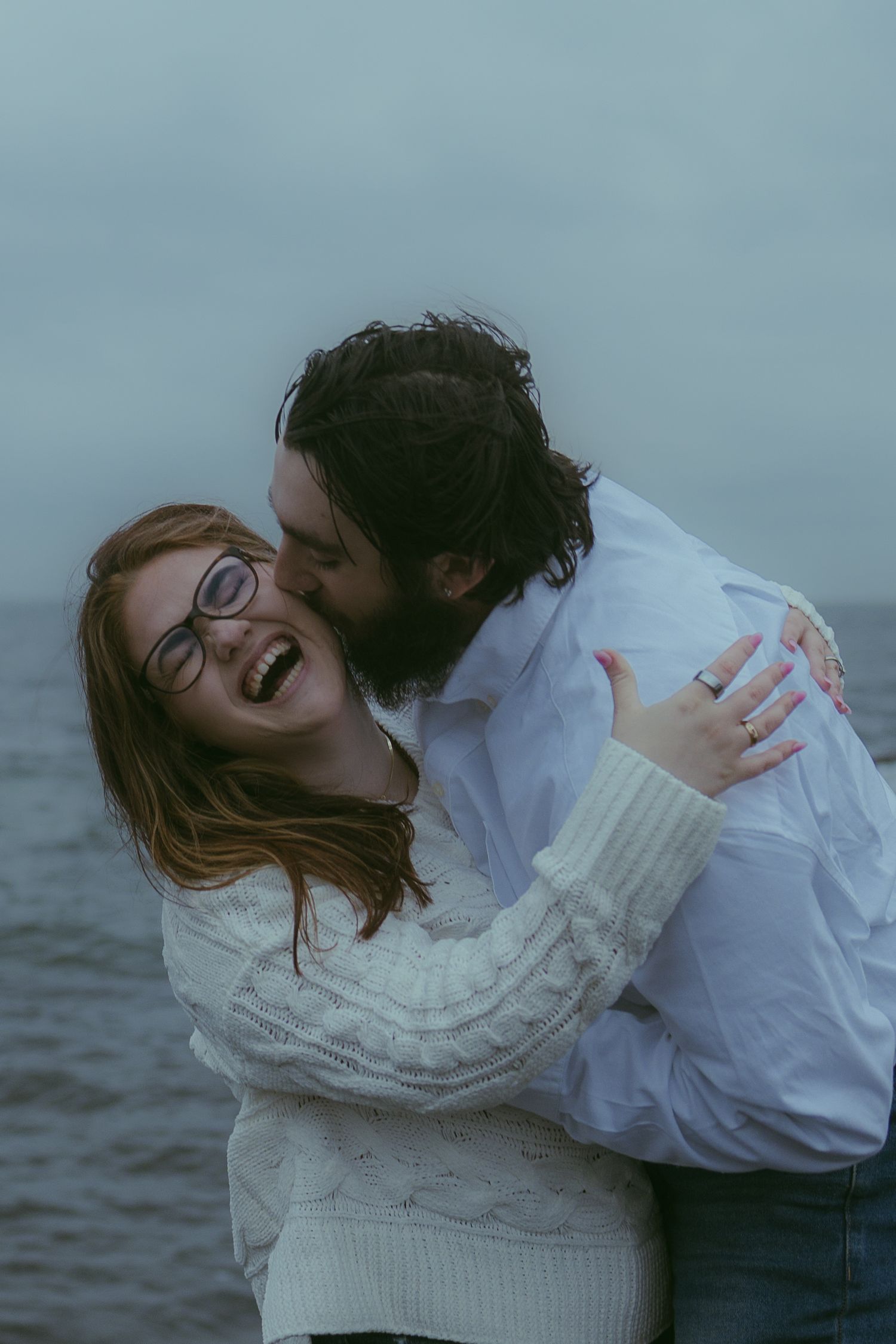 A playful winter photoshoot by the ocean in cozy sweaters.