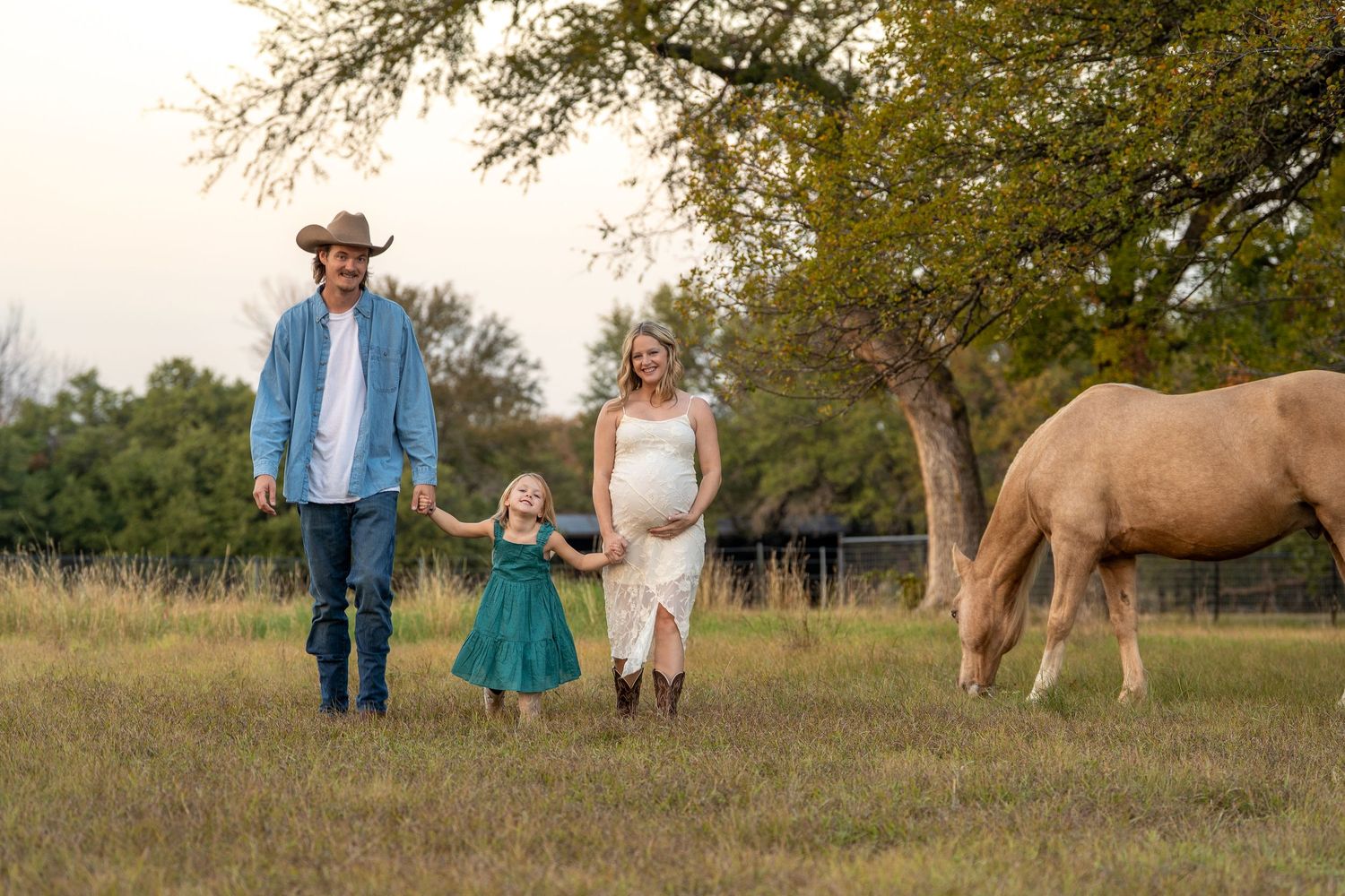 Western style family with pregnant woman and horse.