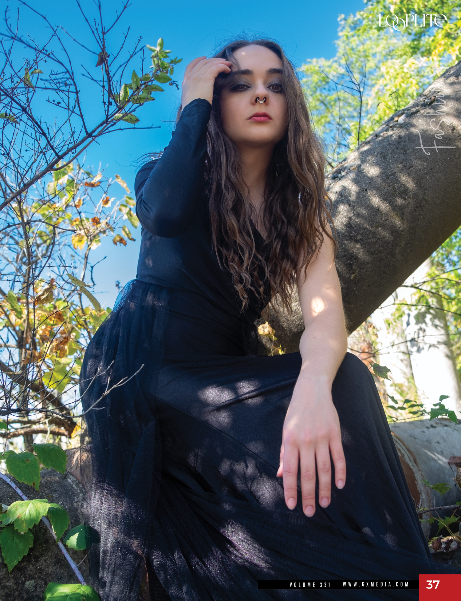 Artistic outdoor fashion portrait with dramatic shadows and natural setting.