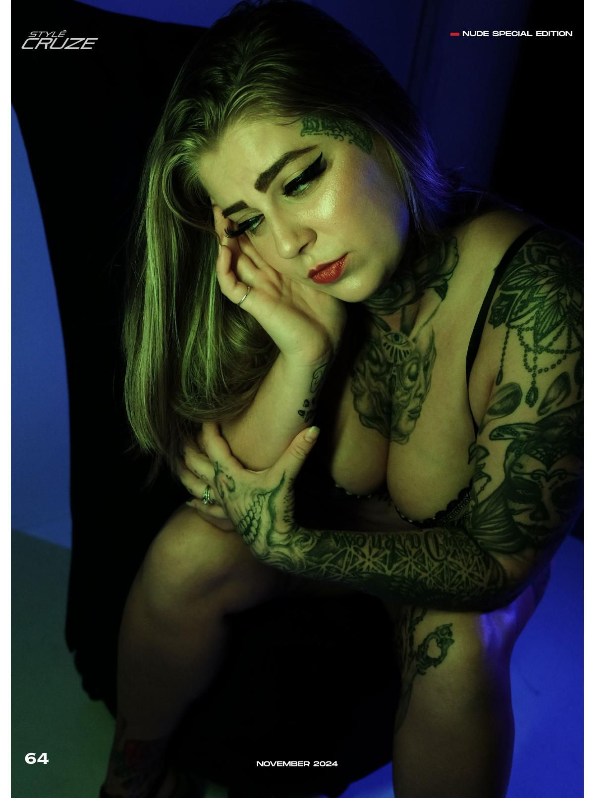 Moody boudoir portrait with artistic lighting and visible tattoo artwork.