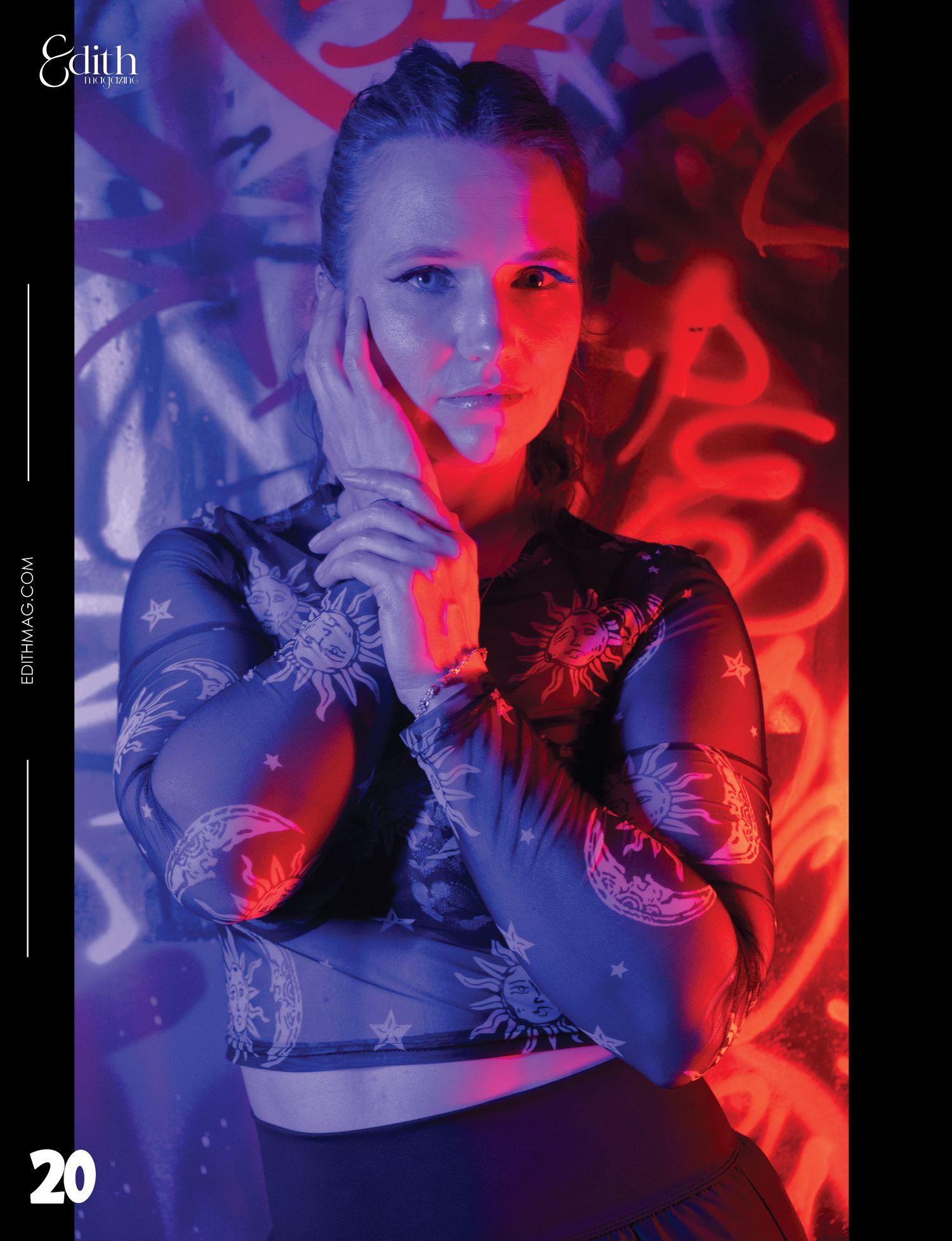 Dramatic fashion photo with neon lighting and floral mesh top against graffiti background.