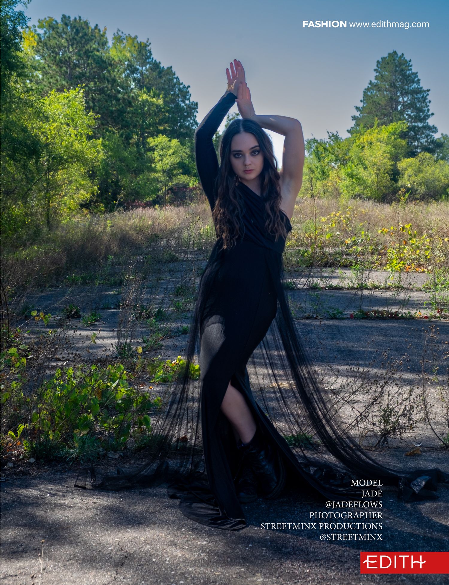 Fashion photo of flowing black dress with dramatic pose in sunlit outdoor location.