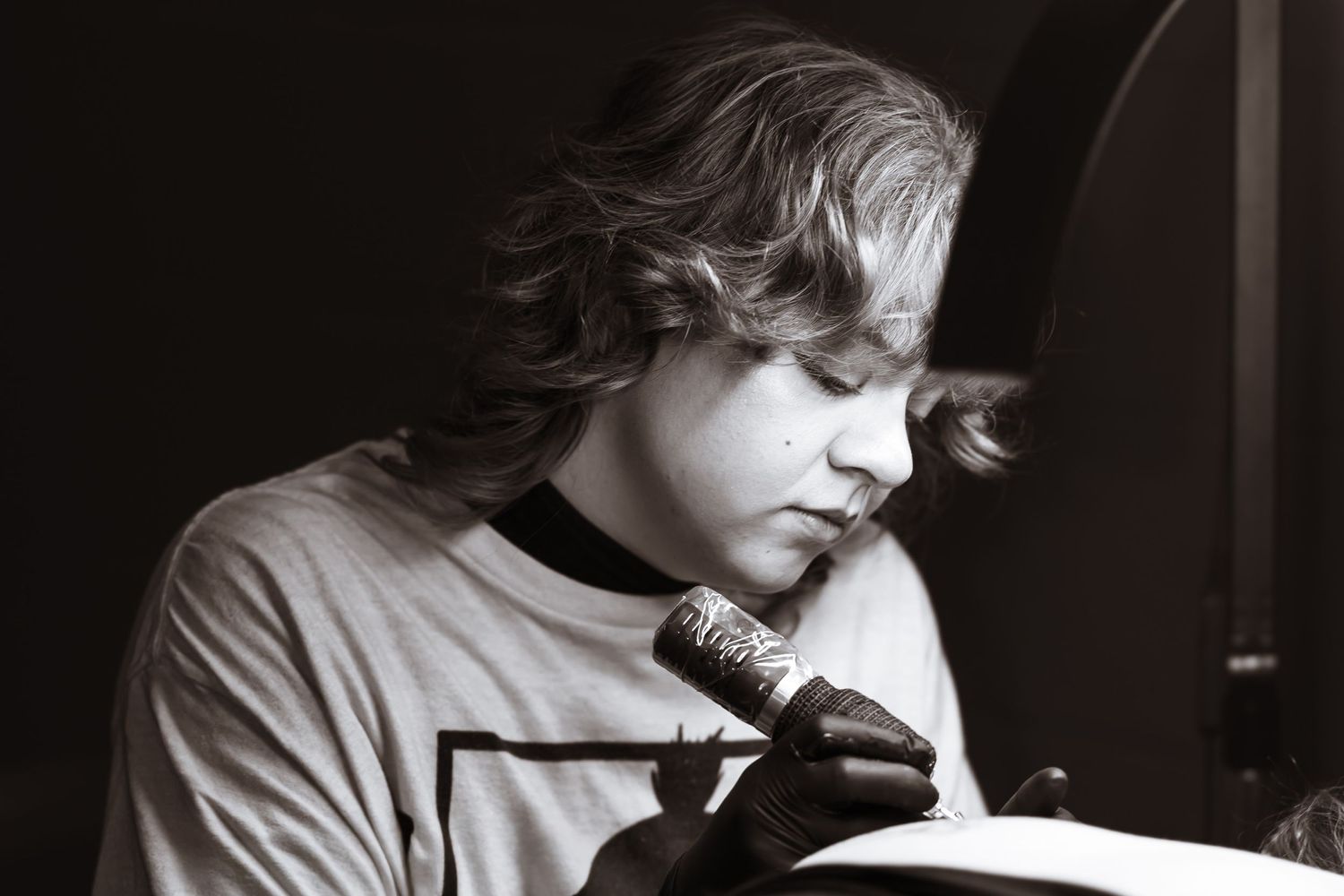 Black and white photo of female tattoo artist.