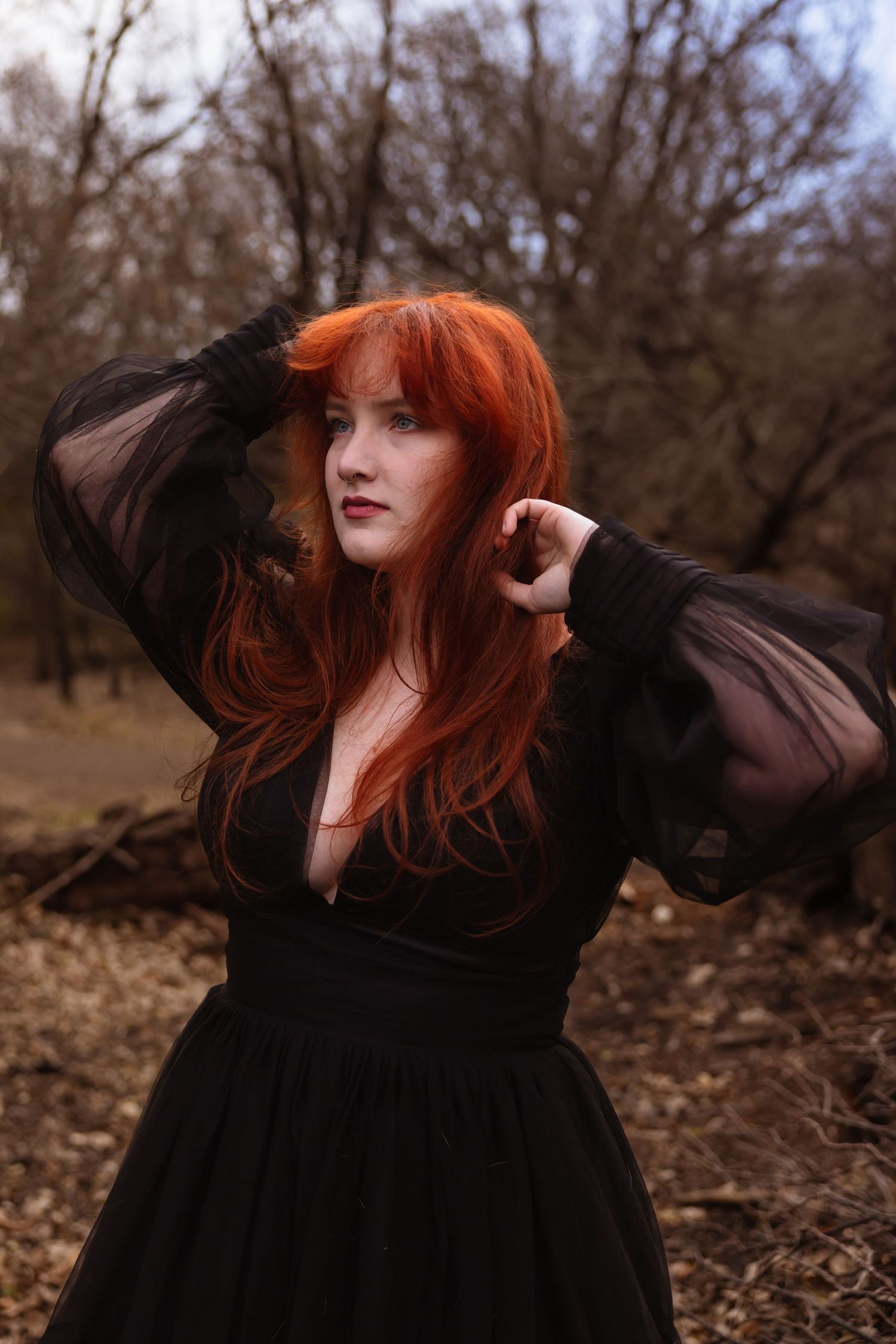 A portrait session of a women in the woods in a flowy black dress.