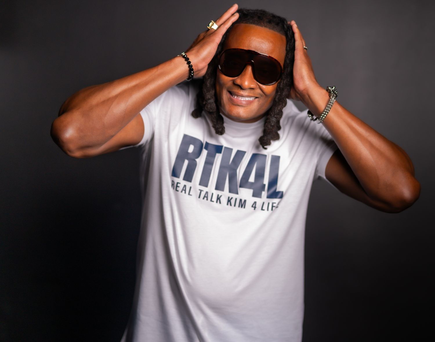 Person in white t-shirt with text making expressive poses against dark background in multiple shots.